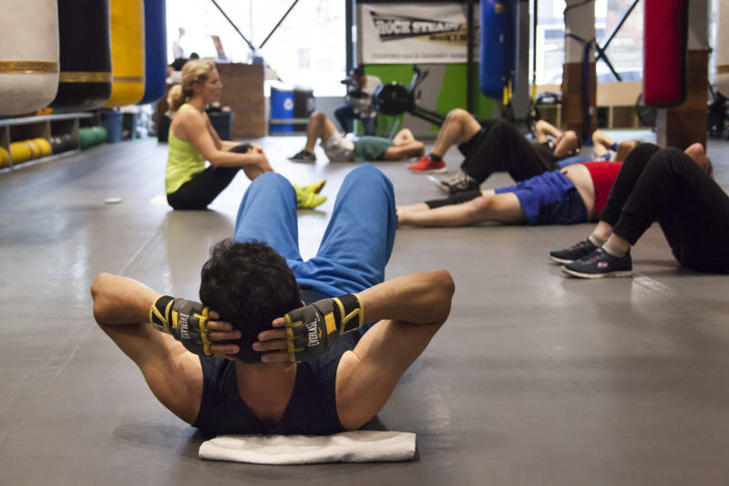 Fighters in the Rock Steady boxing class lay on the floor before starting their abdominal exercises at the end of the workout.