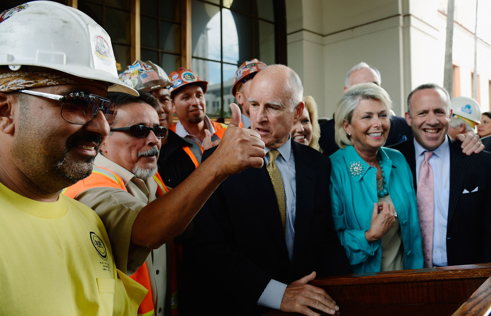 Gov. Jerry Brown is surrounded by construction workers and elected officials after signing legislation authorizing initial construction of the high-speed rail line at Union Station on July 18, 2012 in Los Angeles.