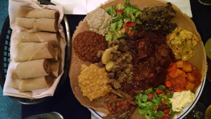 An Ethiopian dinner with lamb wot in the center.