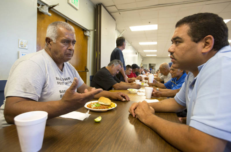 Rigoberto Bejarano (L) talks with intake coordinator Salvador Mendoza at Proyecto Pastoral. The group established The Guadalupe Homeless Project in 1988.