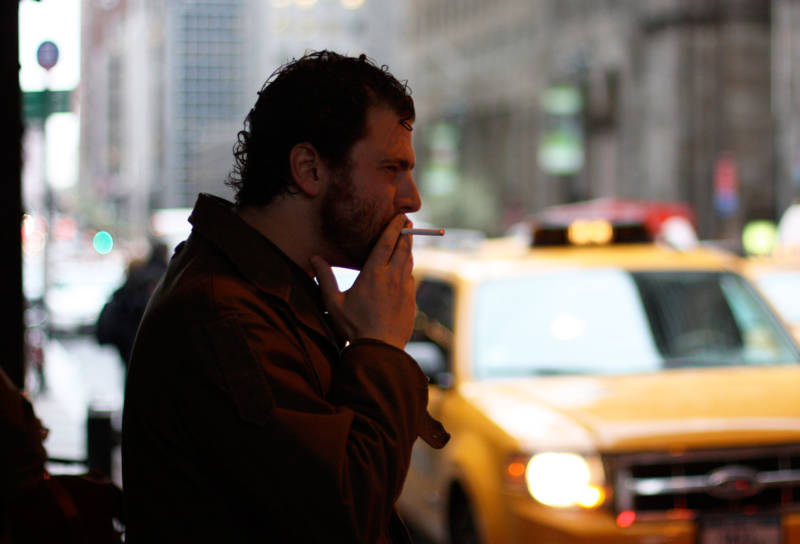 A man smokes a cigarette in New York City, where the current tobacco tax is $4.35 a pack.