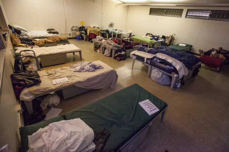 A couple people sleep in a dormitory at a Navigation Center in San Francisco. Unlike other centers, couples are allowed to push their beds together here, and dogs sleep with their people. 