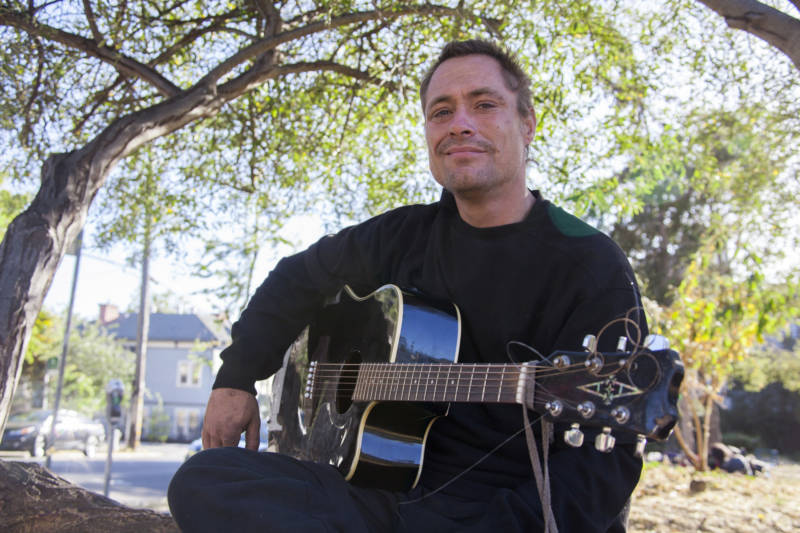 "Thumper" sits for a portrait in the People's Park in Berkeley, Calif. where he is currently homeless and plays guitar to earn money for food.