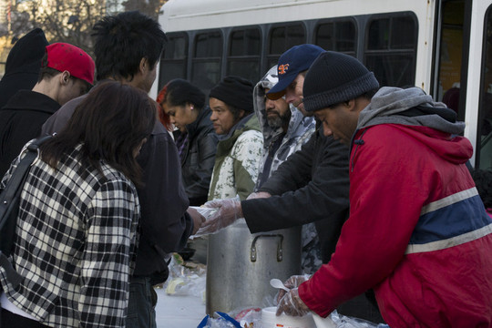 Volunteers with a church group serve free meals to people at U.N. Plaza in San Francisco.