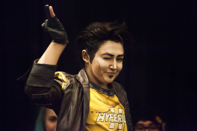 Cosplay character Handsome Jack, from the video game Borderlands: The Presequel, winks and waves on stage during the GX 4 Cosplay Pageant