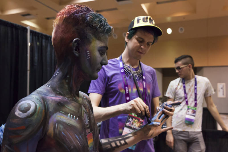Body painting artist Brandon McGill paints the hand of model Ty Monzingo at GaymerX’s GX4 convention.