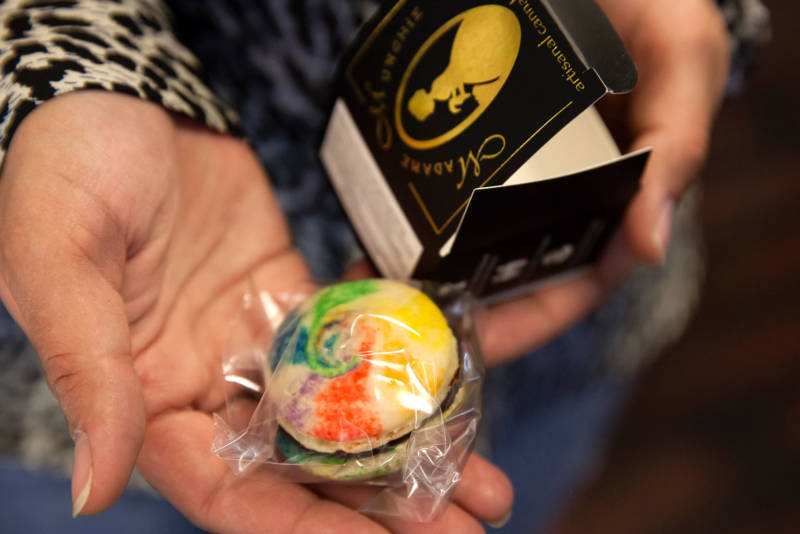 A staff member at a dispensary in San Francisco holds a cannabis-infused macaroon.