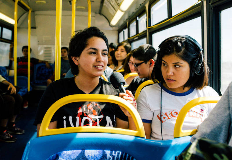 Rosy Mendez (L) rides a slow-moving bus through the Eastern Coachella valley to get to the library to get her homework done.