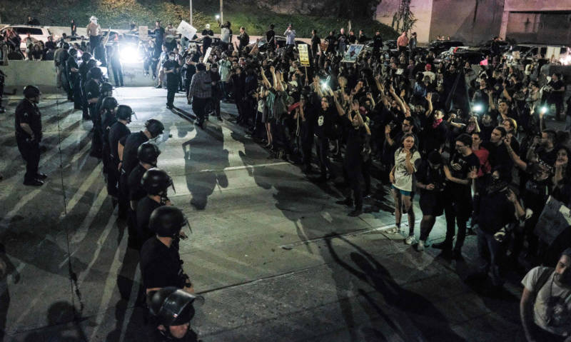 Protesters (R) confront a line of police as they shut down the 101 Freeway in Los Angeles Wednesday night. 