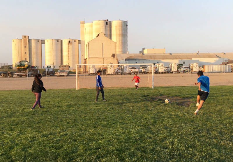 With remnants of the old sugar factory in the background, Tanimura and Antle employees play soccer after working in the fields.