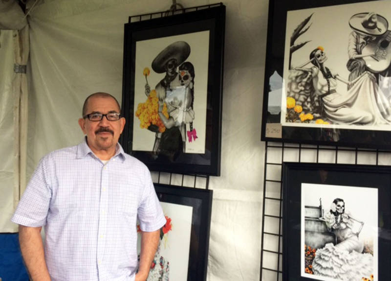 Los Angeles-based Chicano artist Hector Silva stands next to his ornate pencil sketches at Oakdale Memorial Park in Glendora for Dia de los Muertos Celebration.