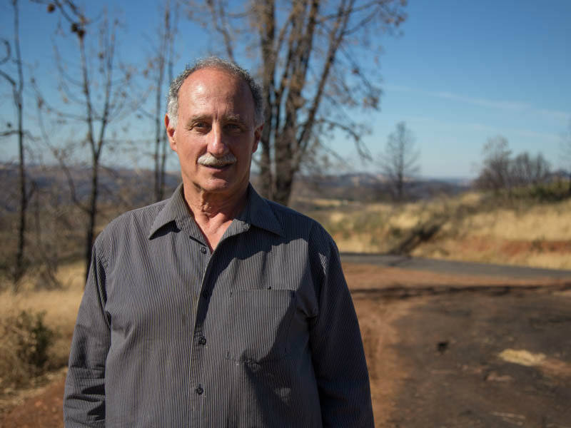 Apple farmer and former Calaveras County Supervisor Steve Wilensky stands on a hillside burned in the 2015 Butte Fire.