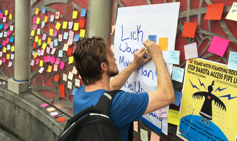 People attach messages of support and empathy to the walls at the 16th St. BART station in San Francisco. 