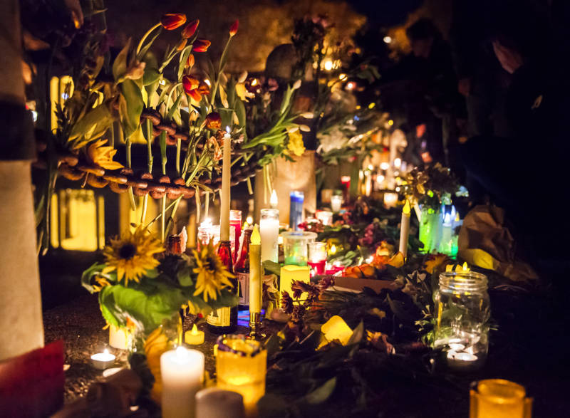 Candles were laid out along the edge of Lake Merritt during the vigil, while flower were tucked into chain railings and layered among the candles.