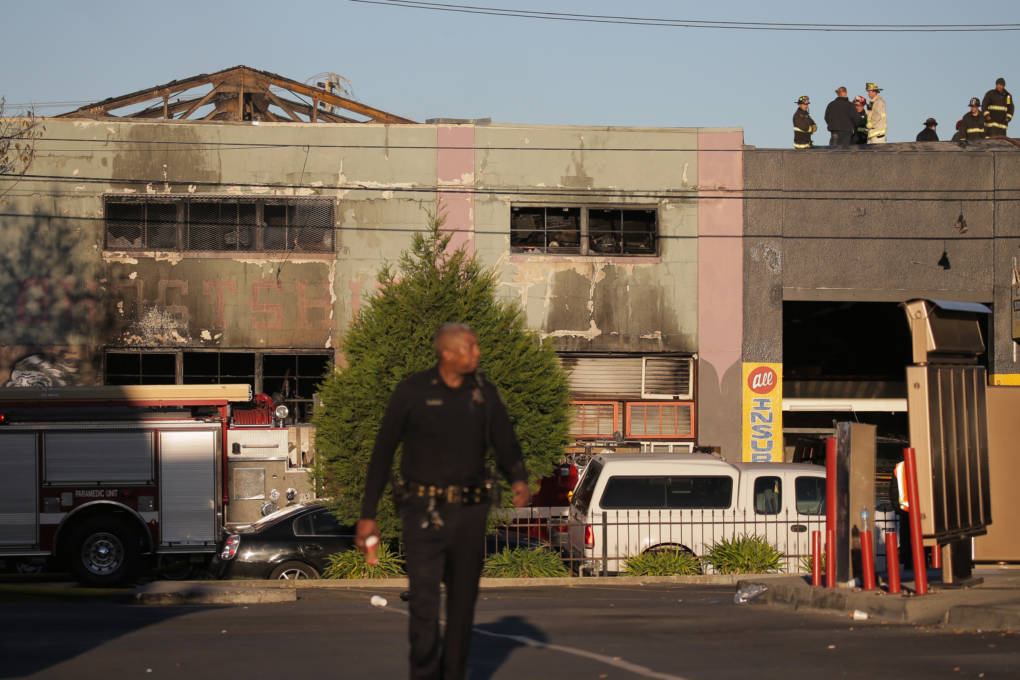 OAKLAND, CA - DECEMBER 03: Firefighters and police at the scene of a overnight fire that claimed the lives of at least nine people at a warehouse in the Fruitvale neighborhood on December 3, 2016 in Oakland, California. The warehouse was hosting an electronic music party. 
