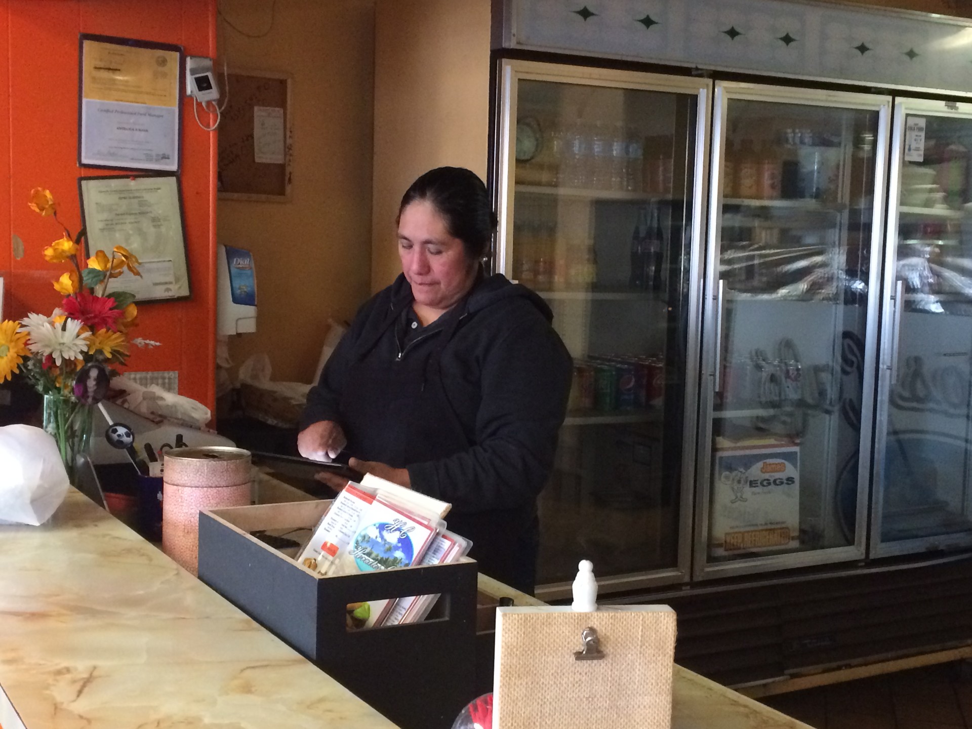 Edith Gallegos works the register at Hornitos Cafe, blocks away from the Ghost Ship warehouse fire. Gallegos said her clientele plummeted during recovery efforts at the fire site, which closed nearby streets.
