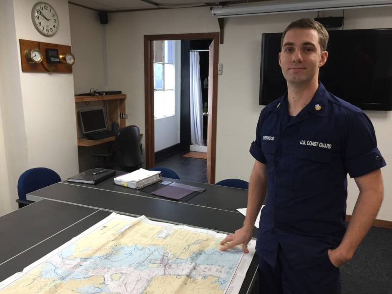 U.S. Coast Guard Petty Officer John Sherwood poses with a map of sound signals across the San Francisco Bay.