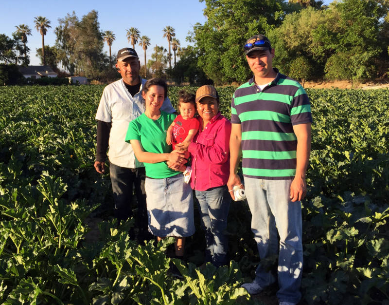 Yuriana Aguilar with her family in their squash field: (L-R) Arturo Aguilar, Yuriana and her daughter Victoria, Ana Torres, and Yuriana's husband, Ismael. Yuriana is the first undocumented student to graduate with a Ph.D. from UC Merced.