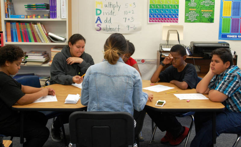 Special education instructional aide Jocelyn Ramirez (middle) works with students in small groups at Oak Ridge Elementary School in the Sacramento Unified School District.