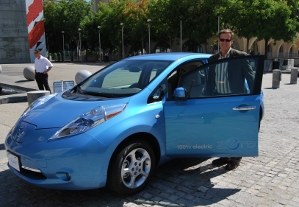 Mark Perry from Nissan standing next to the Leaf, an all electric-vehicle.