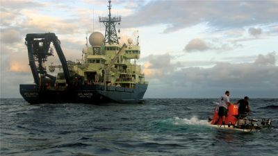 The WHOI-operated research vessel Atlantis serves as support vessel for Alvin operations. During each recovery, two certified swimmers help bring the submersible back to the ship. Photo by Amy Nevala, Woods Hole Oceanographic Institution.