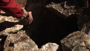 Gordon Clark of The Peninsula Open Space Trust removes rocks that guard the hidden entrance.