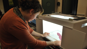 Clare Loughran, who works at the University Herbarium, prepares to take a digital photograph of a red seaweed. 