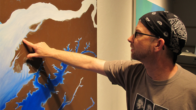 Artist John Sabraw checks the paint on one of his works in progress. The brown pigment is sourced from coal mine runoff.
