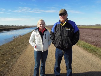 Cranberry Creek Cranberries' plant health manager Nicole Hanson and owner Bill Hatch stand between a water reservoir and a freshly harvest cranberry bed near Necedah. Photo Credit: Maureen McCollum/WPR