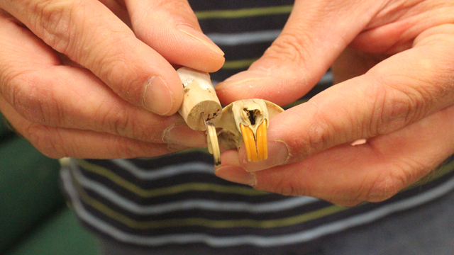 Shane Tucker holds a fossil gopher tooth next to a modern pocket gopher skull.