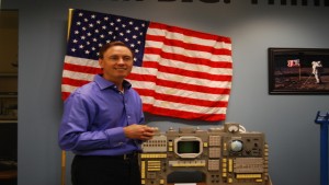 Silicon Valley venture capitalist Steve Jurvetson stands next to some of his space memorabilia, including a prototype of the American flag planted on the moon. Image by Arwen Curry / KQED Science.