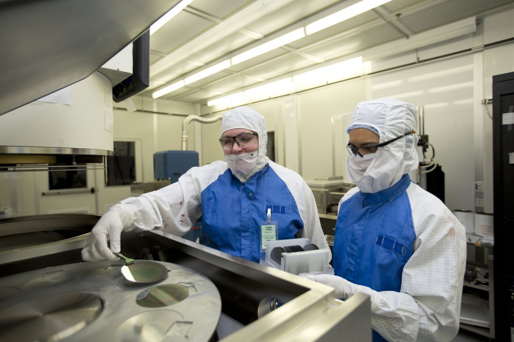 Lawrence Livermore engineers Angela Tooker and Vanessa Tolosa load silicon wafers into a metal deposition chamber during the development of the neural device. (Courtesy of LLNL)