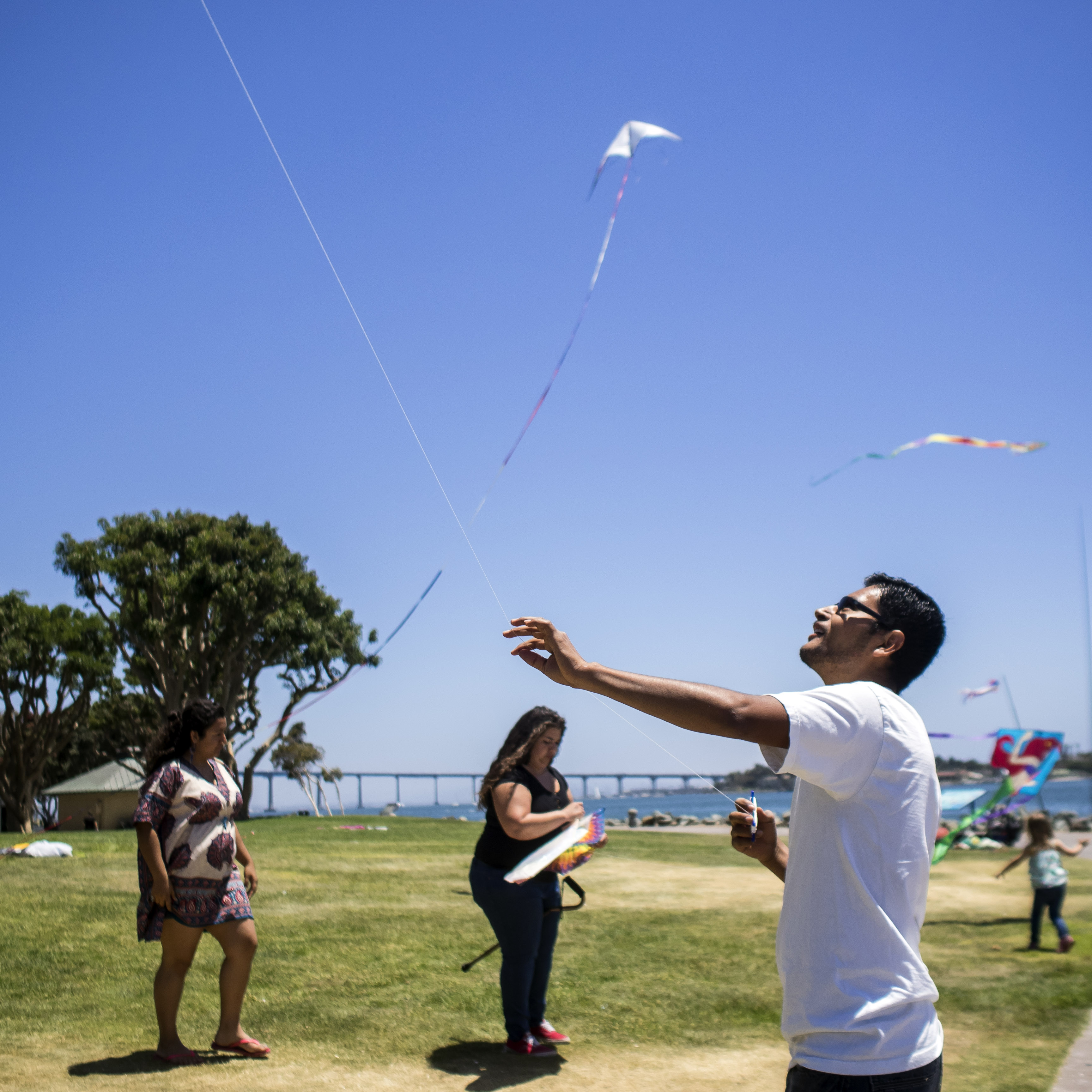 Young people taking part in a mental illness prevention program called Kickstart fly kites at San Diego's Seaport Village. Marvi/KQED)