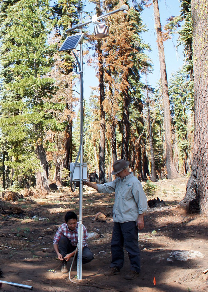 UC Merced's Roger Bales and Ziran Zhang work on a snow sensor tower in the Tahoe National Forest. (Lauren Sommer/KQED)