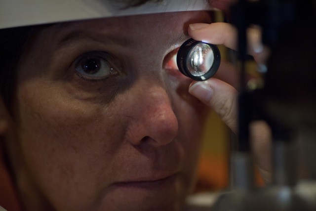 Dr. Linda Olmos De Koo examines Lisa Kulik's prosthetic retina at the USC Eye Institute. The device helps Kulik differentiate between light and shadows so that she can better interpret the world around her. Benjamin Brayfield/KPCC)