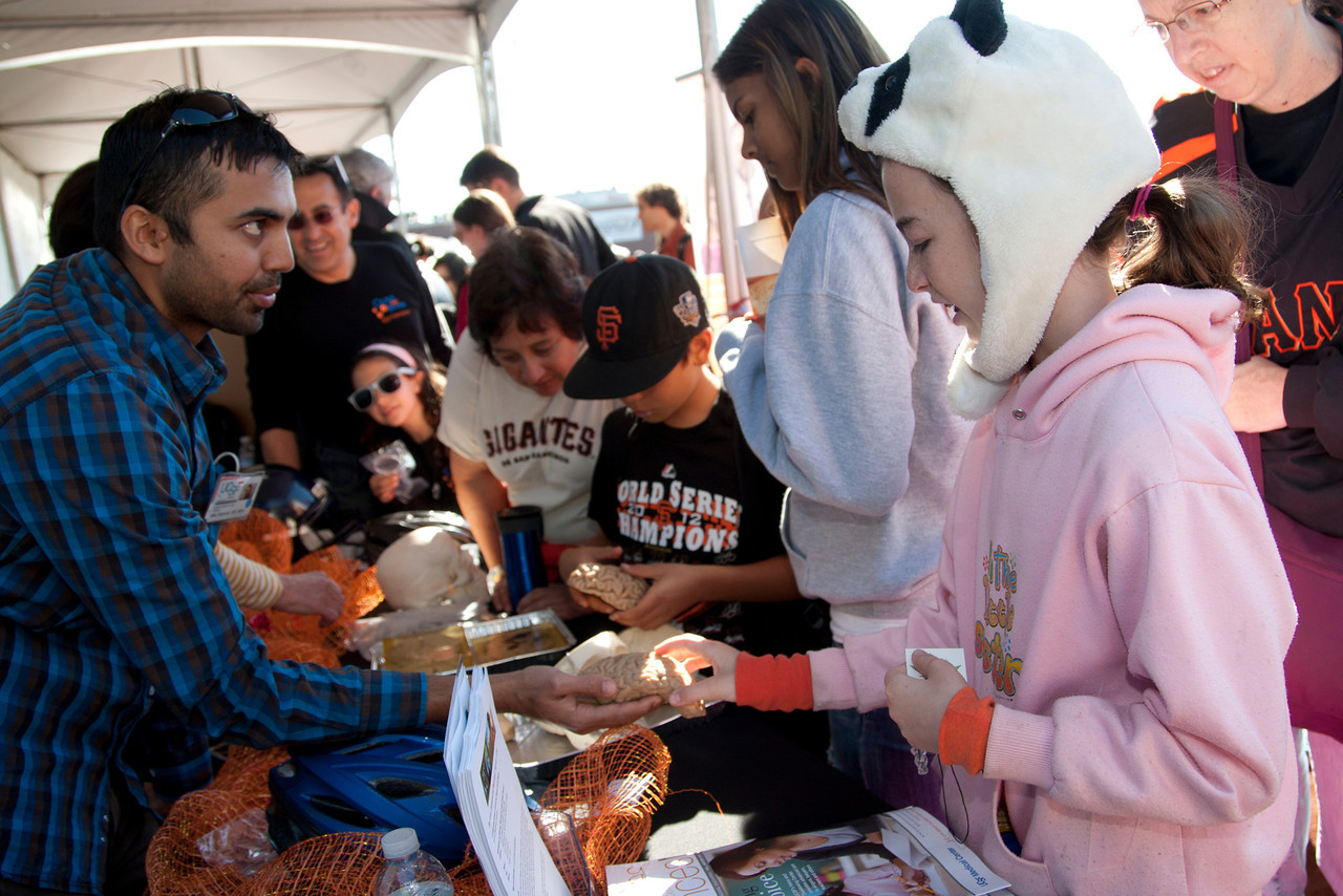 Dr. Mitul Kapadia, left, speaks with Talia Haber, 10, about brain injury prevention at one of the UCSF booths at the Bay Area Science Festival held at AT&T Park in 2012. Photo by Cindy Chew 
