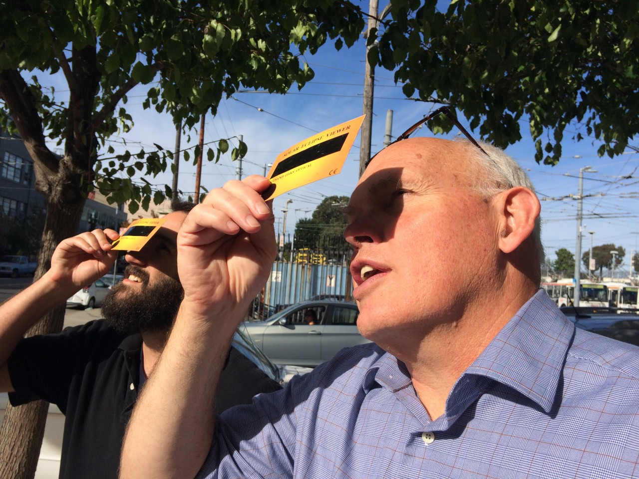 Adam Grossberg and Dan Brekke of KQED step outside to see the eclipse. (Olivia Hubert-Allen/KQED)