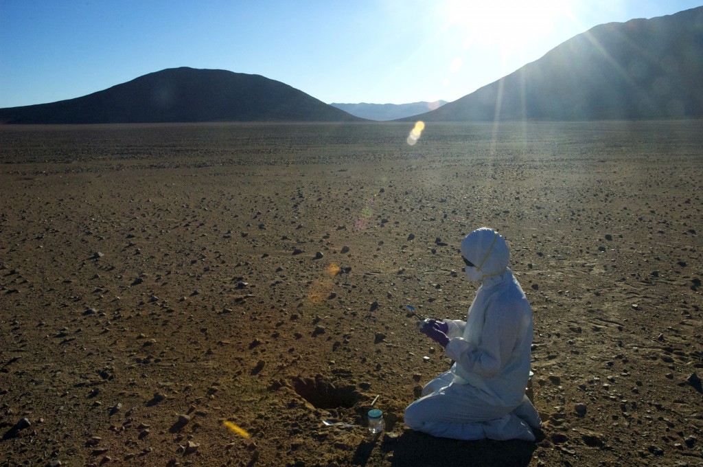 Clean sampling of biomarkers in the desert soil requires suits, gloves, masks, goggles, and sterile tools to make sure no contamination ends up in the soil sample. 