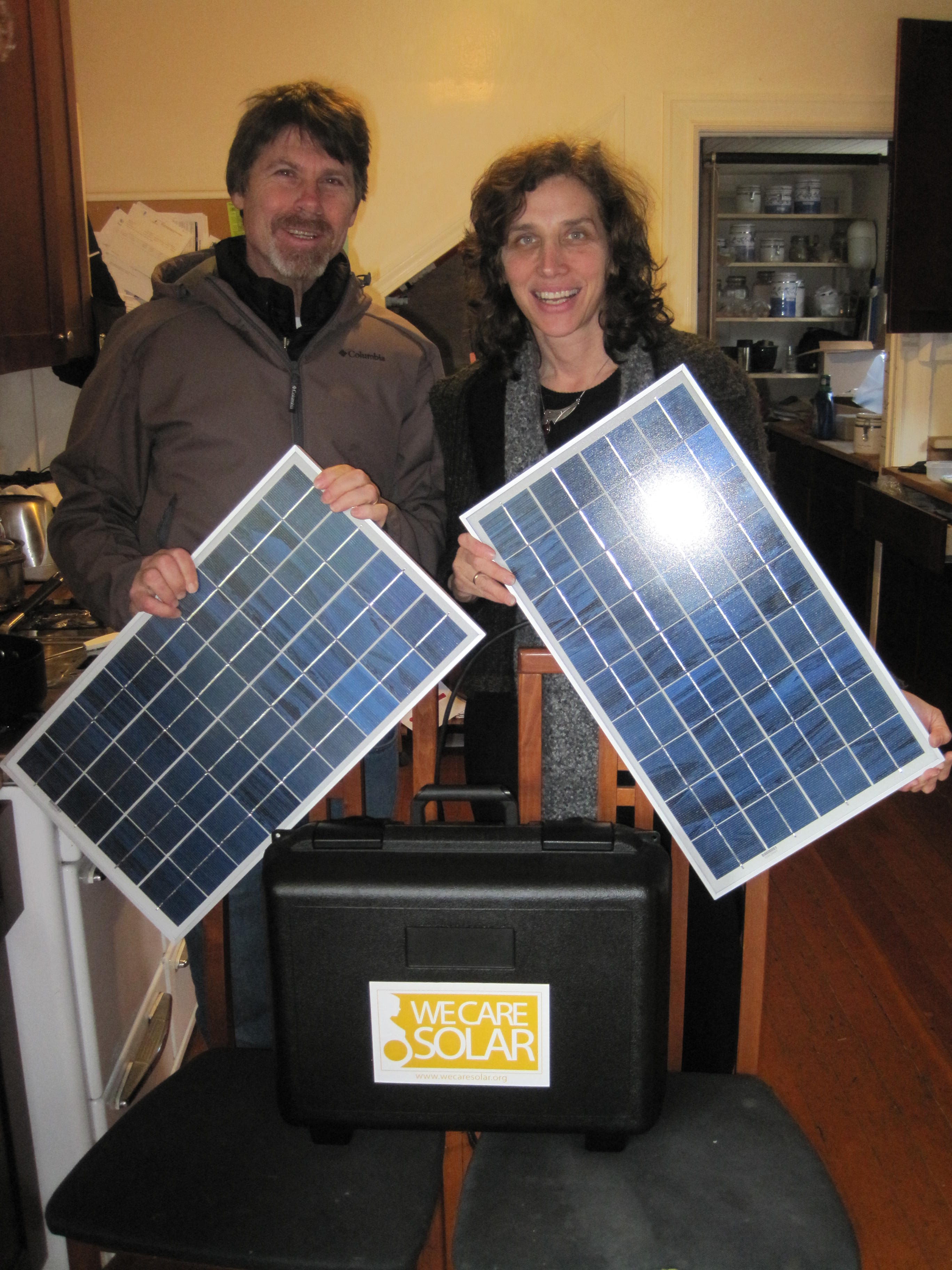 We Care Solar co-founders Hal Aronson and Laura Satchel hold the panels for a solar suitcase prototype that was sent to Africa to power medical clinics.