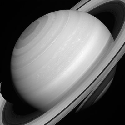 Saturn's seemingly serene cloud-tops, polar vortex, and translucent rings.