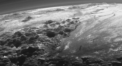 Pluto's ice mountains casting sunset shadows across the cold landscape.