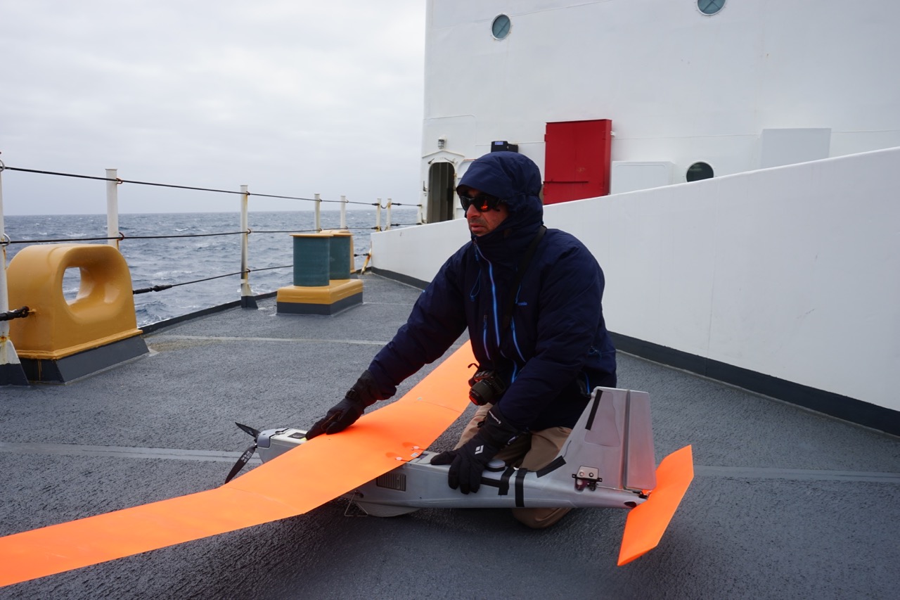Todd Jacobs of NOAA holds the Puma down against high winds.