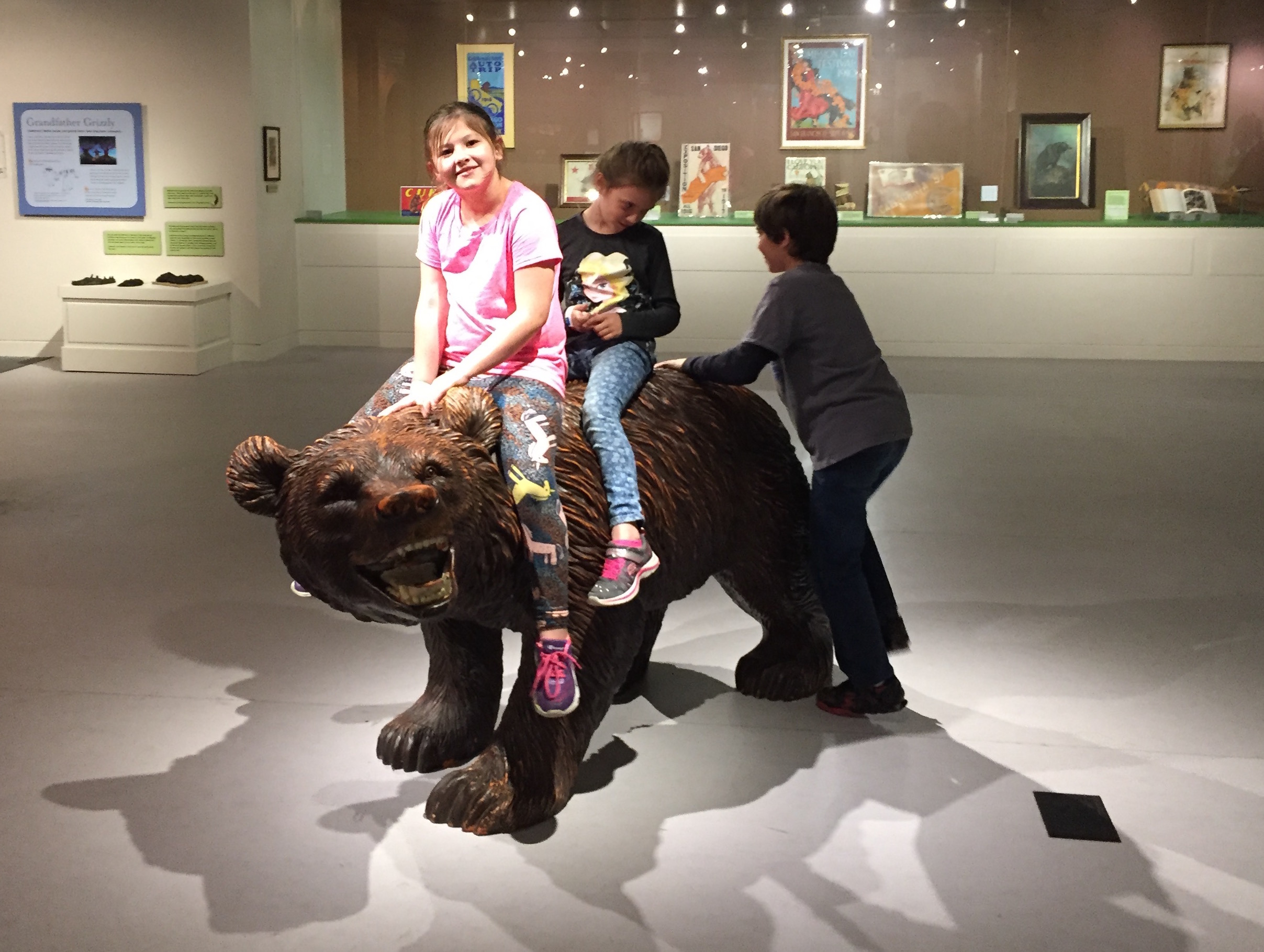 Kids play on a grizzly bear sculpture at the California Museum in Sacramento.