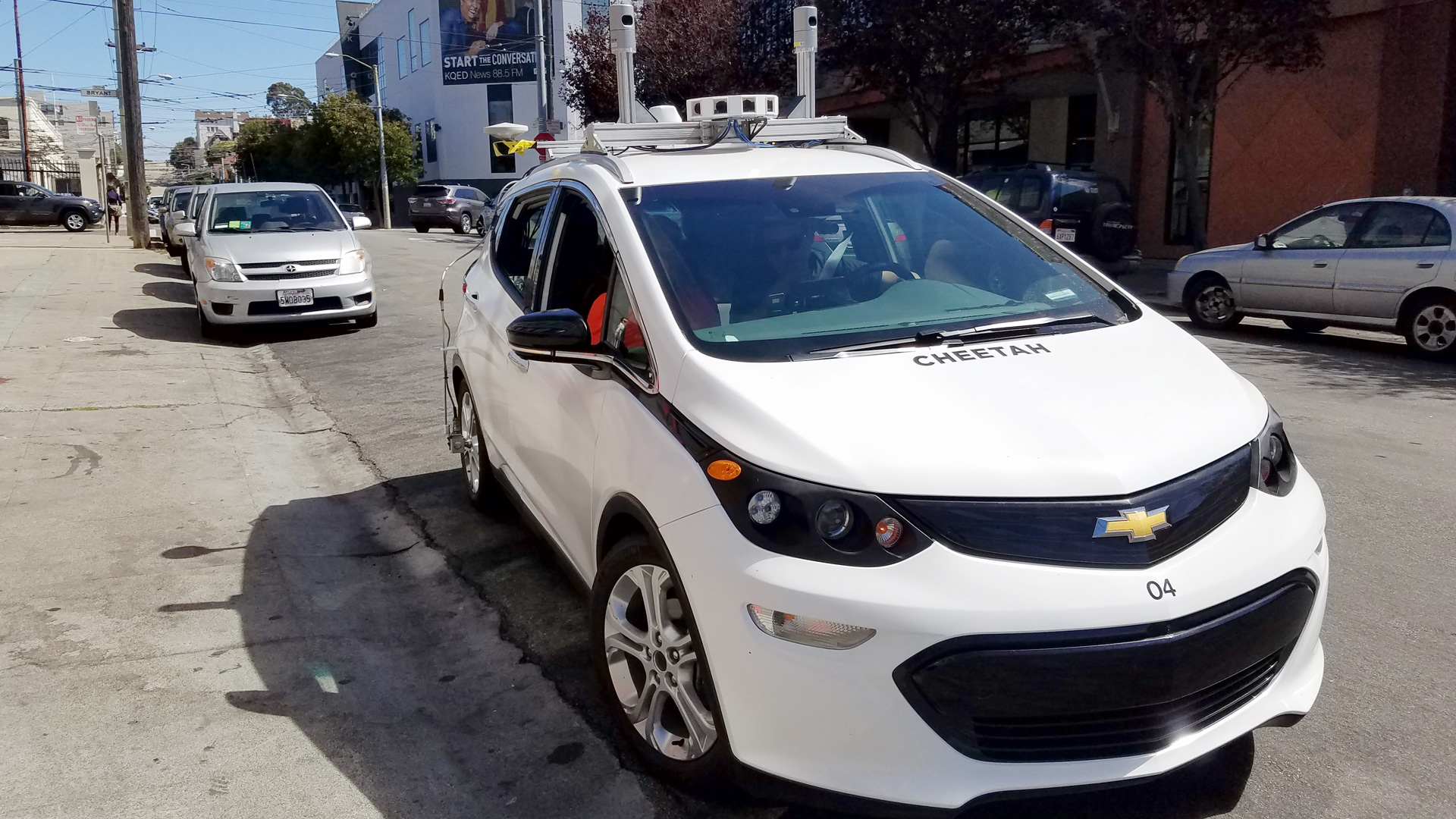 A Chevy Volt with self-driving car technology in front of KQED. 