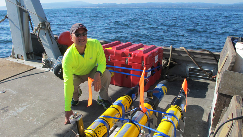 NASA/JPL's Steve Chien with some of the submarine drones being tested in Monterey Bay as autonomous ocean exploring robots. 