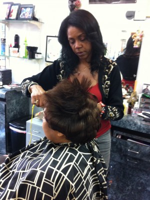 Patricia Davis straightens a clients hair at her salon in Oakland.