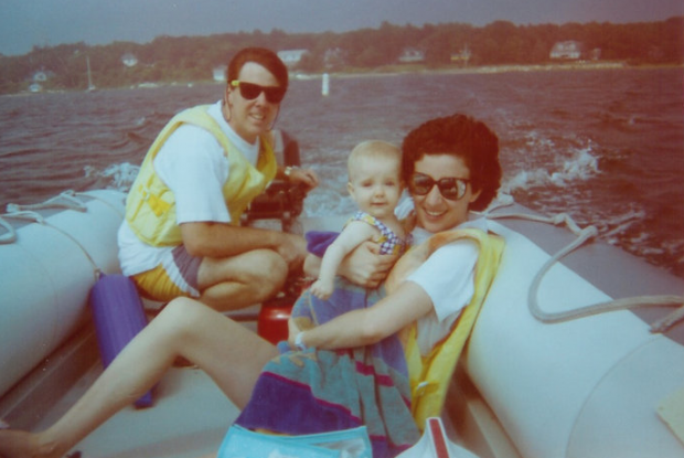 A young Kristen Powers is held by her mother, Nicola, while her father looks on in the background. Nicola was later diagnosed with Huntington’s disease, a fatal illness. (Photo courtesy of Kristen Powers)