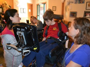 Speech-language pathologists Jill Tullman (left) and Mendi Carroll (right) work with Bryce Vernon at Talking with Technology Camp in Empire, Colo. (Kristen Kidd/KCFR).