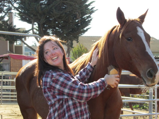 Kaitlyn Pintor visits with horses at Hoof Beats riding school in Petaluma. For the past decade, a nerve disorder has made it painful for her to experience touch. (Ryder Diaz/KQED) 
