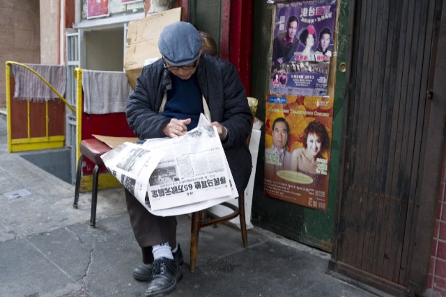 A man reads a Chinese-language newspaper in San Francisco's Chinatown. In the 19th century, the Chinese community was often excluded from mainstream healthcare, and in response, it founded its own Tung Wah medical dispensary. That grew into Chinese Hospital, and later, into CCHP. (Marcus Teply/KQED)